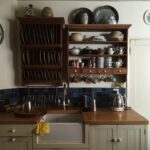 white kitchen cupboards and rack with dinnerware arranged on it