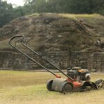 a lawn mower sitting on top of a dry grass field