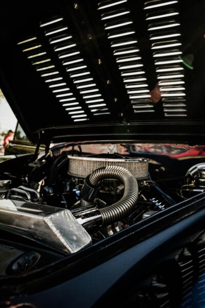 Close-up view of vintage car engine with open hood, camshaft position sensor