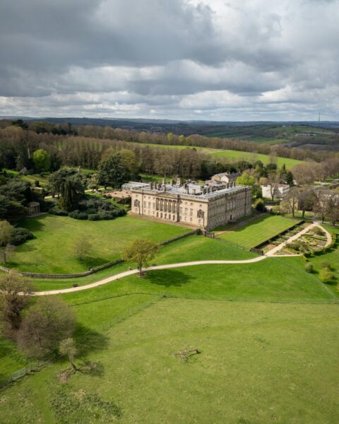 Spectacular aerial photograph of Wentworth Castle and gardens in Barnsley, England with lush spring greenery.