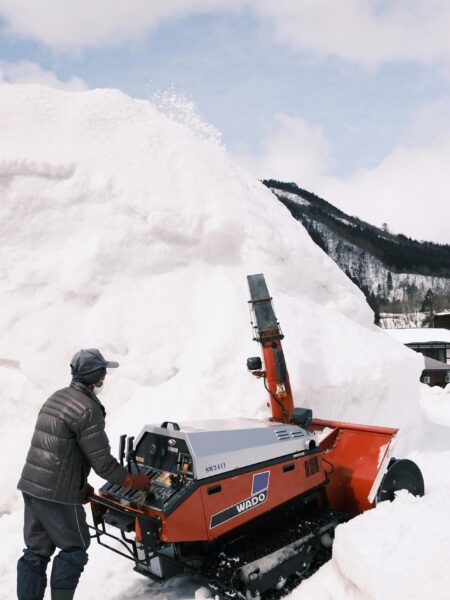person operating snowblower in winter scenery