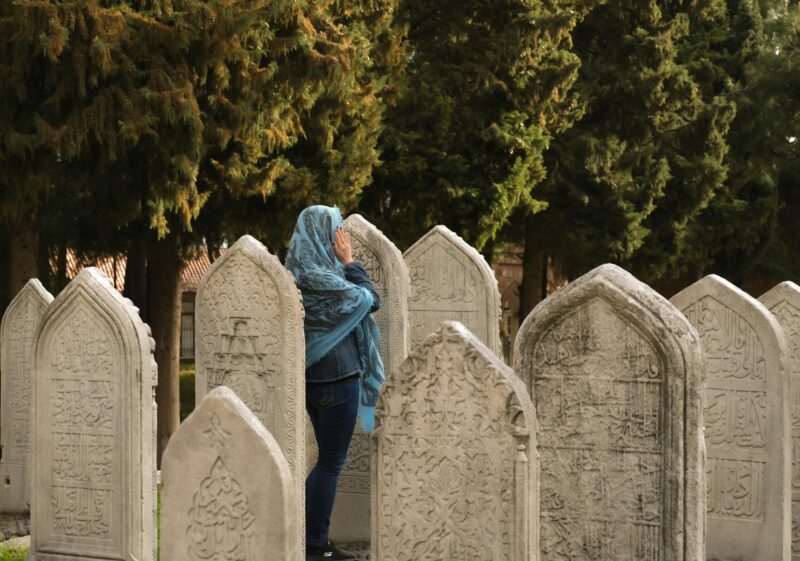 Woman Reflecting in Cemetery Tombstones Trees