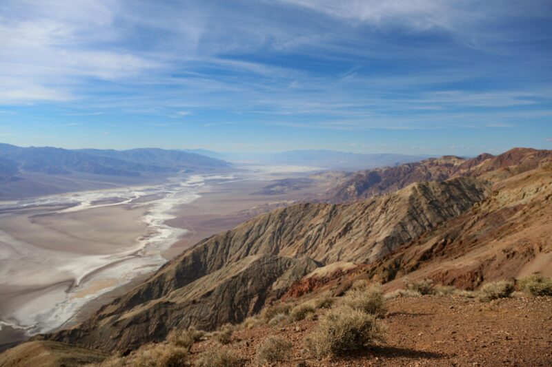 Breathtaking view over Death Valley National Park's dramatic desert landscape under a vivid blue sky.
