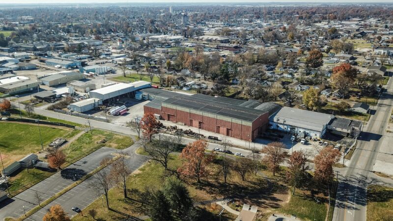 Aerial view of Owensboro, KY, capturing industrial buildings and autumn foliage.