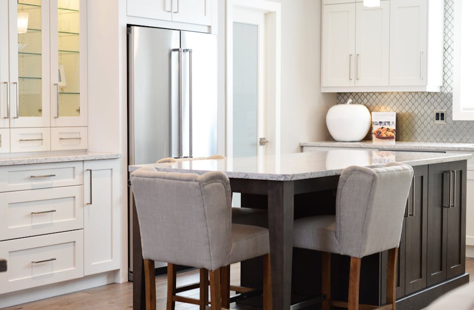 Spacious modern kitchen with elegant interiors featuring a dining table and luxurious design.