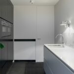 white stainless steel sink with faucet beside closed door