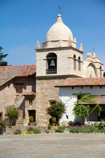 Carmel Mission Basilica showcasing its historic tower and lush gardens.