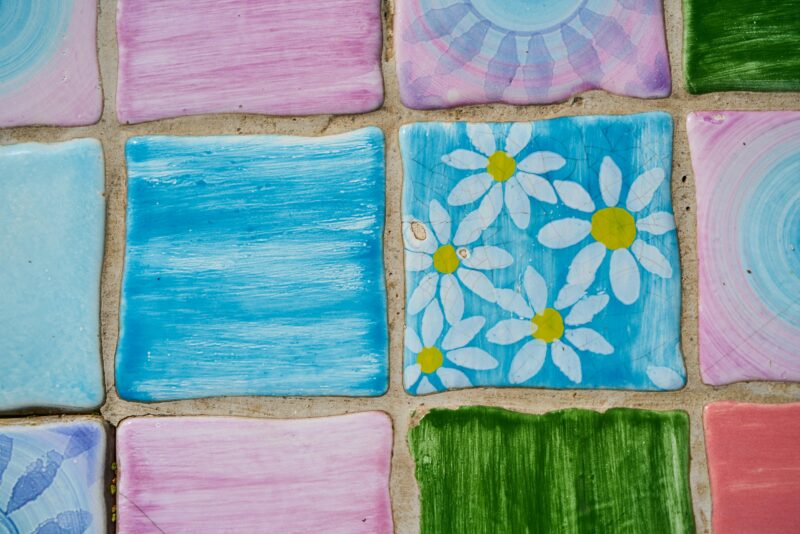 Vibrant hand-painted ceramic tiles with floral designs, adding artistic flair to any decor.