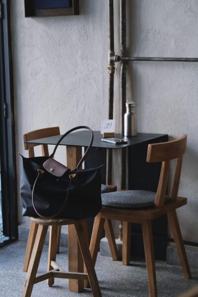 A fashionable tote bag on a chair in a cozy café corner, perfect for lifestyle themes.