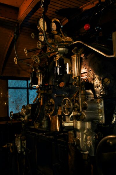 Close-up of a vintage steam train engine's interior, highlighting gauges and controls.