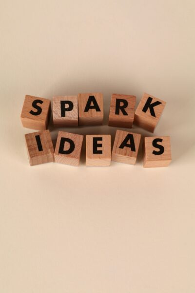 Wooden blocks spelling 'Spark Ideas' on a beige background, symbolizing creativity and inspiration.