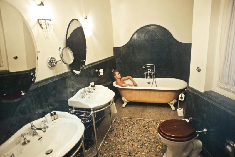 A peaceful scene in a vintage-style bathroom with a woman relaxing in a bathtub.