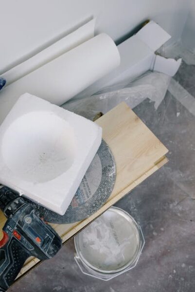 Plywood plank and renovation tools on a dirty floor