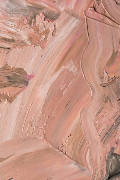 Close-up of a textured pink abstract oil painting featuring dynamic brushstrokes and layered pigments.