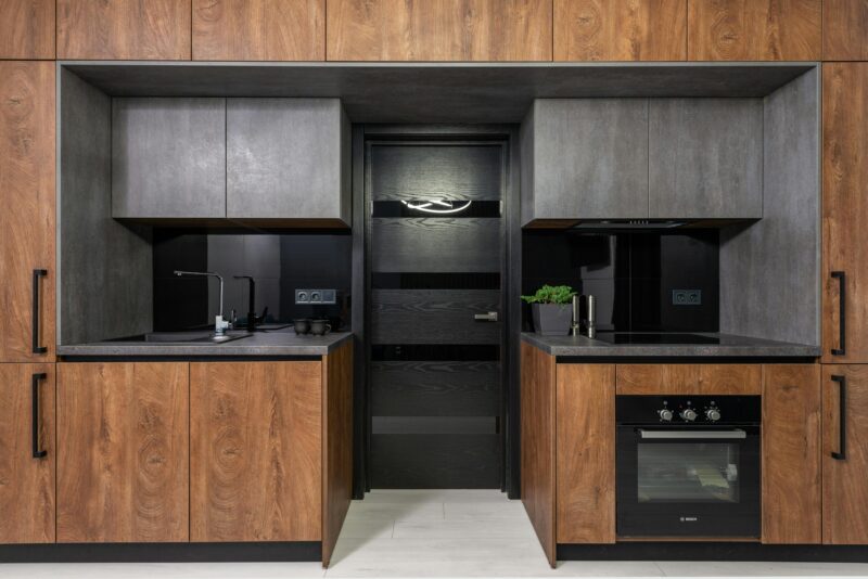 Sleek modern kitchen with wood and grey tones, highlighting minimalist style.