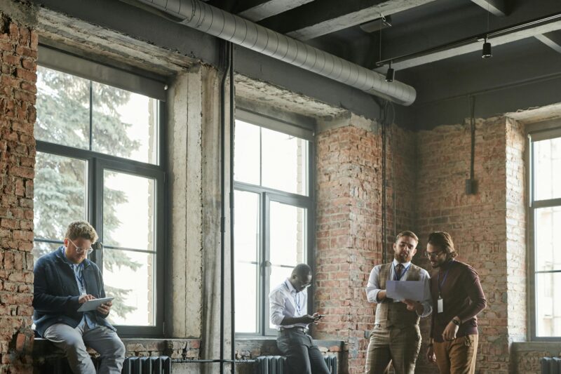 Casual business meeting in a loft-style office with a diverse team sharing ideas.