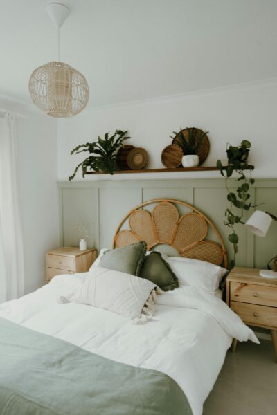 Comfortable bohemian bedroom featuring wicker details and green accents.