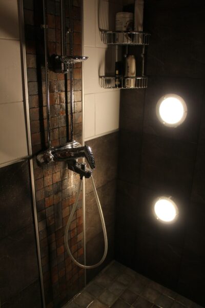 Gray stainless steel faucet in a modern shower.