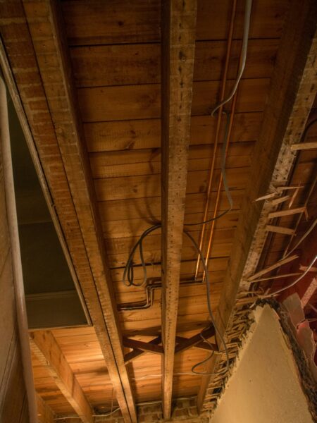White and brown wooden ceiling in an exposed basement.