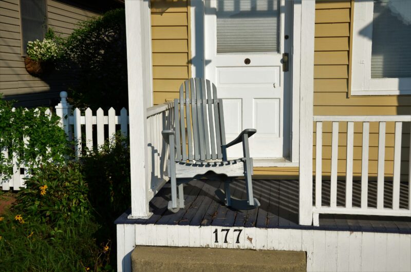 White wooden rocking chair near white wooden fence