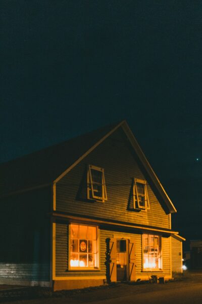 A yellow house with windows lit up at night