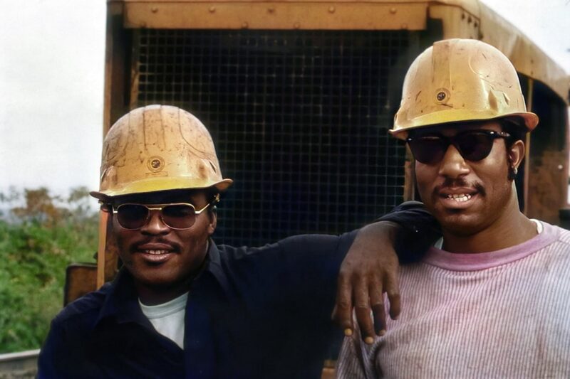 Two men wearing hard hats standing next to each other
