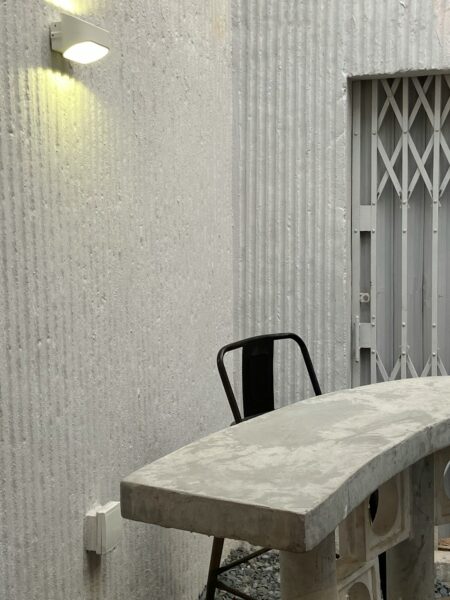 A concrete table and chair in front of a building.