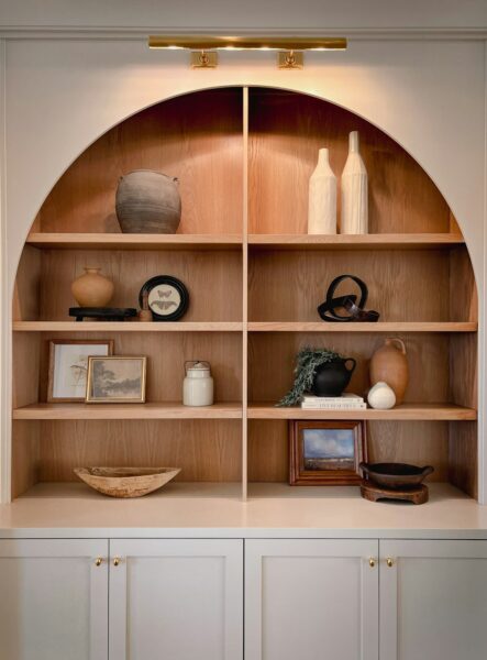 A wooden shelf filled with vases and other items