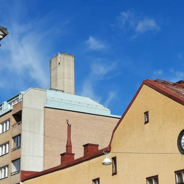 A view of traditional and modern roofs in Stockholm, Sweden, with a blue sky.