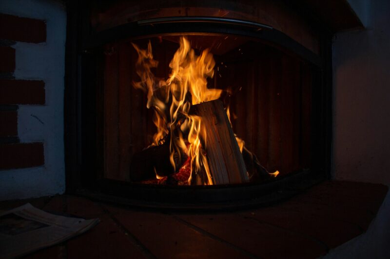 A fire burning inside of a wooden stove, perfect for cozy evenings.