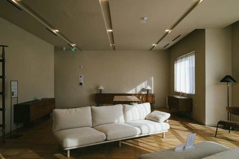 A white couch sitting in a living room next to a window