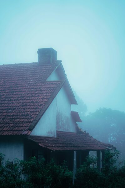 A white house with a red roof in the fog.