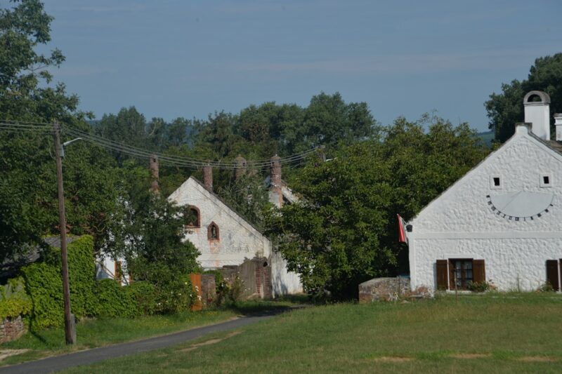 A couple of white buildings sitting next to a lush green field