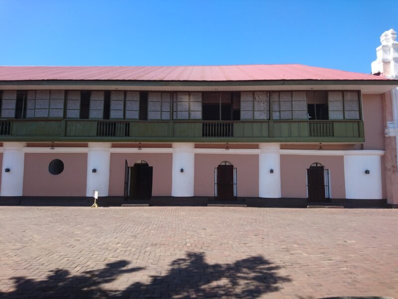 A pink and white building with a red roof