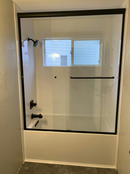 Bathroom with glass shower door and tile floor