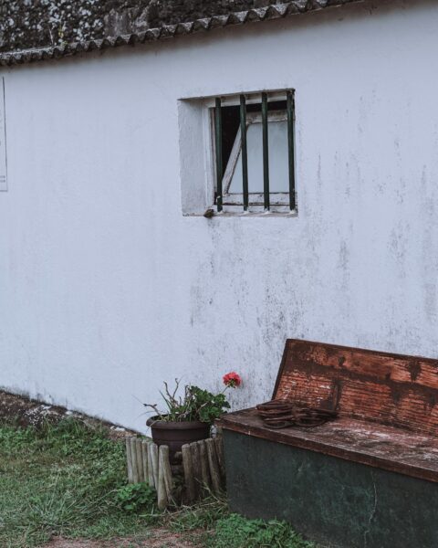 A wooden bench sitting in front of a white building