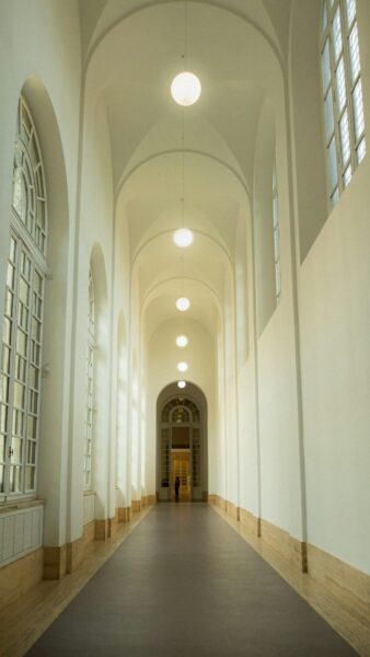 A long hallway with a clock on the wall.