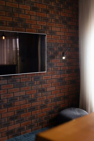 A television mounted to a brick wall in a room