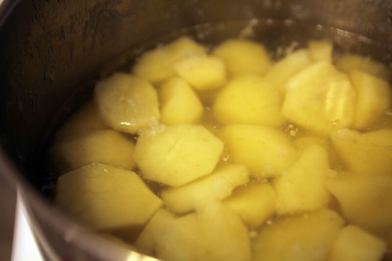 Boiling sweet potatoes in a container.