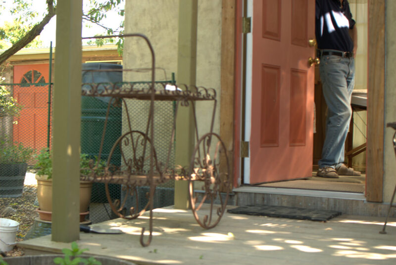 small deck of a tiny house with Richard Heinberg in the background