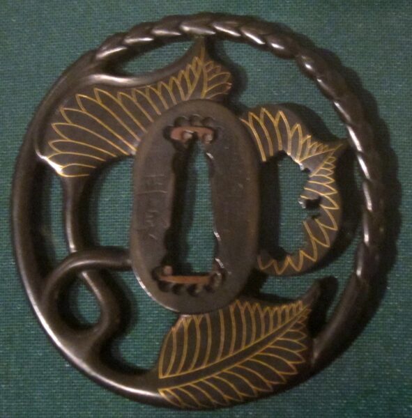 Sword guard (tsuba) with hollyhock leaves and stems.