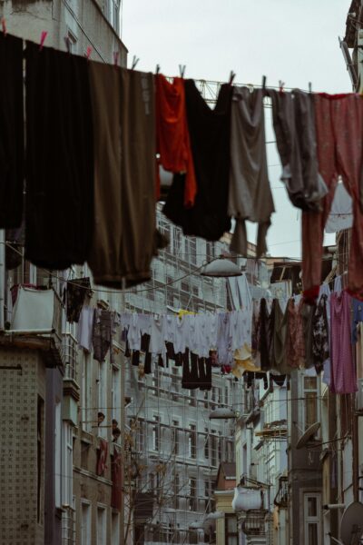 Clothes hanging on a line between apartment buildings in an urban area.