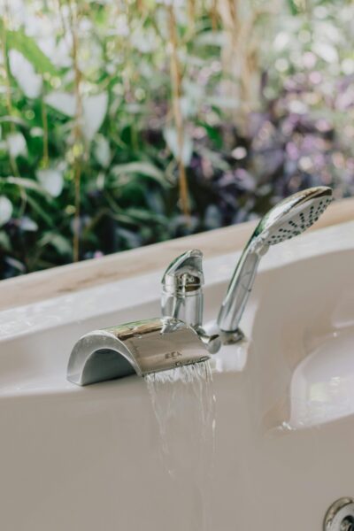 Elegant bathroom design featuring a modern bathtub faucet with scenic greenery visible through the window.