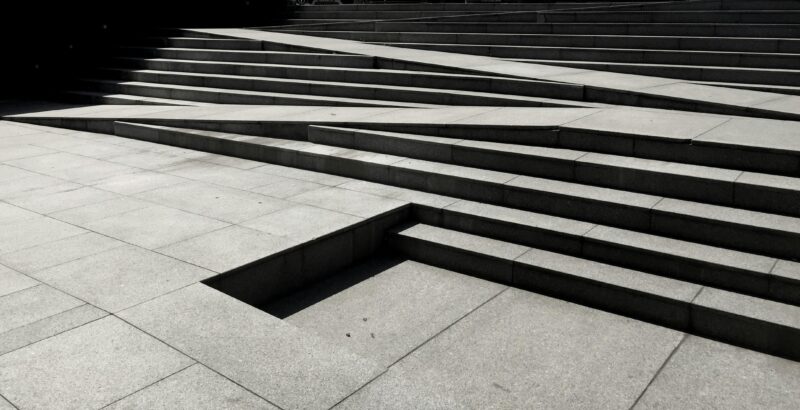 Dynamic view of modern geometric concrete steps in Bucharest, showcasing urban architecture.