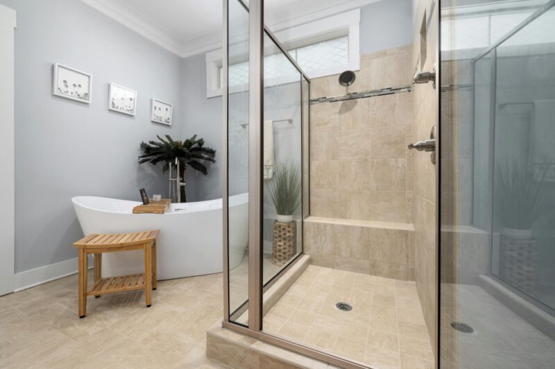 A clean, modern bathroom featuring a bathtub and glass shower with minimalist decor.