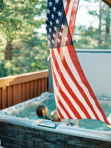 Enjoying a summer day in a jacuzzi with the American flag flying high. Perfect for patriotic celebrations.