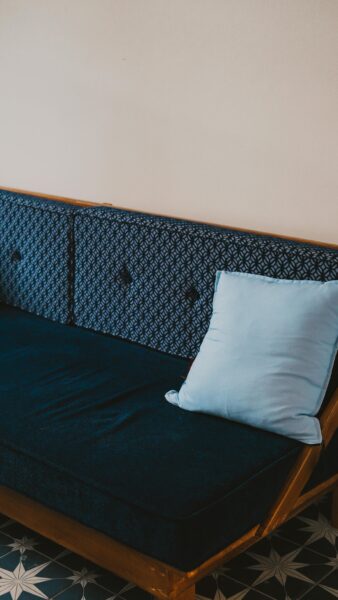 Comfortable blue sofa with patterned fabric and pillow in a stylish living room setting.