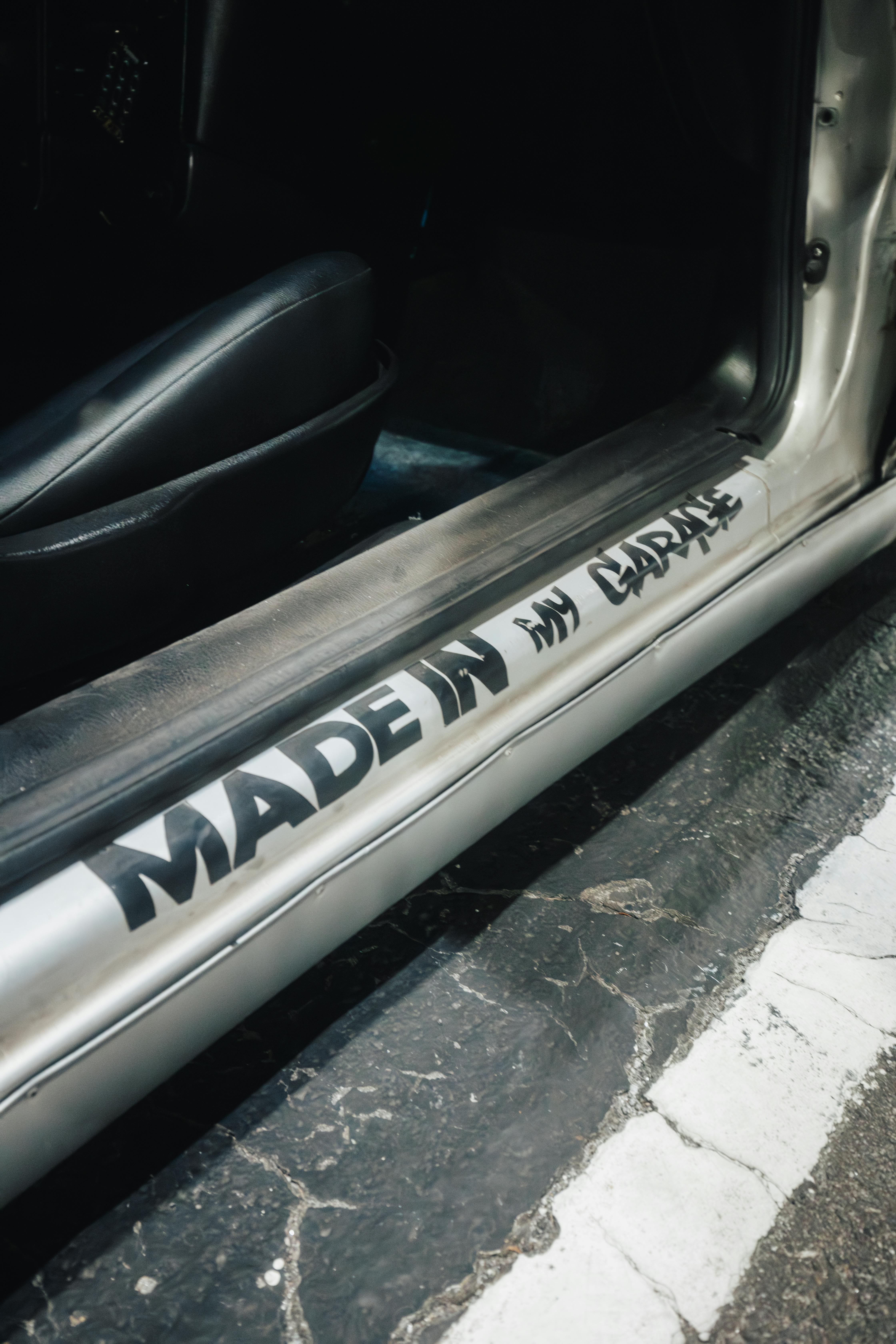 Vertical shot of a car door threshold with a custom 'Made in my garage' message.