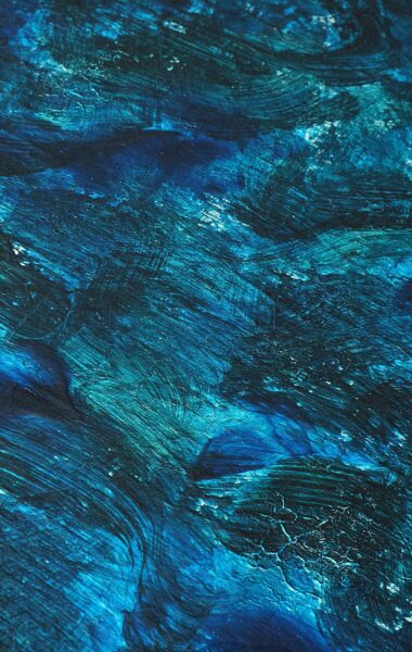 A dynamic abstract painting with rich blue tones and textured brushstrokes evokes movement and depth.