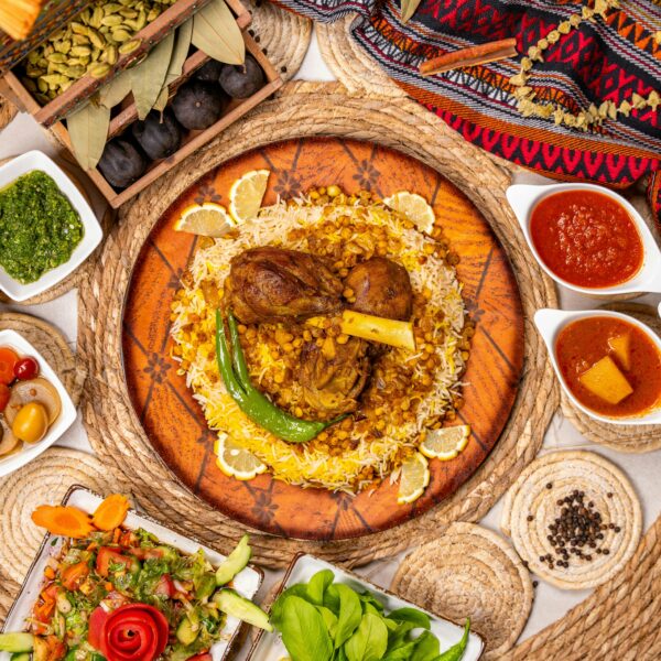 A vibrant Middle Eastern Mandi dish with lamb, rice, and vegetables styled with assorted sides.